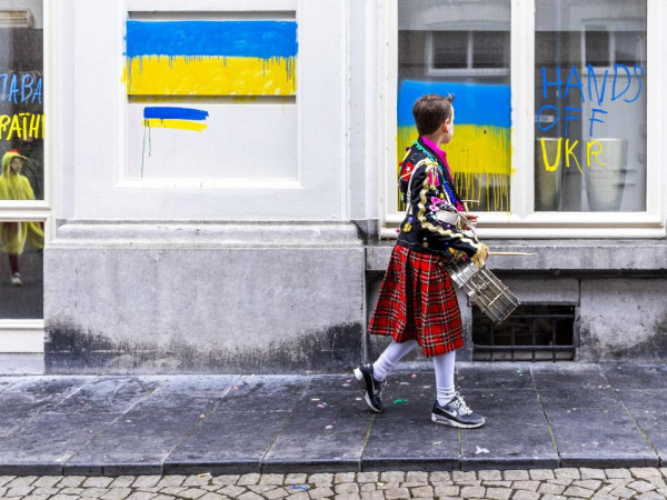 Maastricht, Olanda. Davanti al consolato russo un giovane vestito da carnevale non può non osservare i colori dipinti sui vetri del palazzo. Credit: Epa, Marcel Van Hoorn