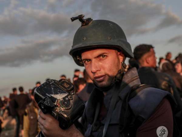 Il fotografo palestinese Moahmmed Asad mostra la telecamera distrutta durante uno scontro a fuoco al confine tra Israele e la striscia di Gaza (EPA/MOHAMMED SABER)
