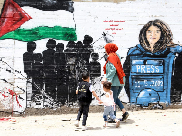 Alcuni palestinesi camminano davanti a un murale dedicato alla giornalista di Al Jazeera Shireen Abu Akleh nella città cisgiordana di Betlemme