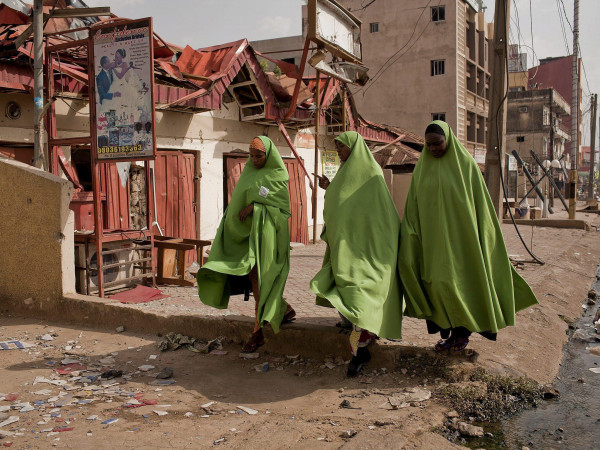 Donne musulmane nigeriane camminano tra le macerie in seguito alle esplosioni provocate lo scorso aprile a Kaduna