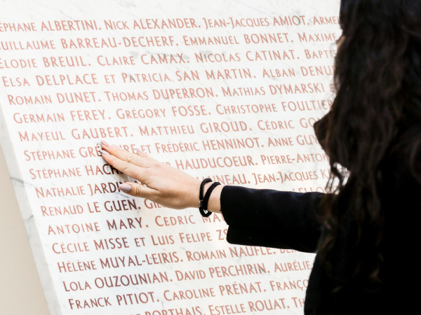 Parigi (Francia). Una donna scorre i nomi delle vittime degli attentati terroristici del 13 novembre 2015, in cui furono uccise 130 persone. Una delle targhe commemorative si trova all'interno del Bataclan, dove ci furono 90 vittime.