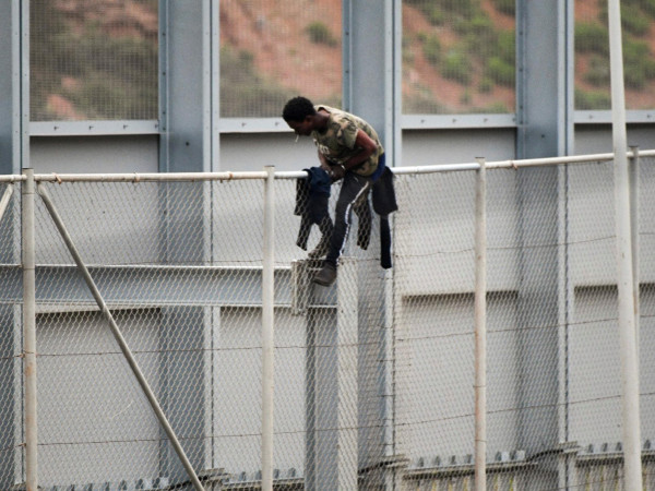 A migrant jumps the fence between Morocco and Ceuta, Spanish enclave on the North of Africa, 13 April 2021.