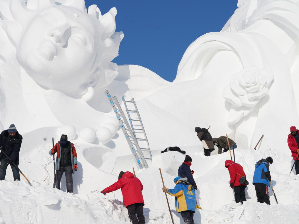 Harbin (Cina). I membri dello staff lavorano su una gigantesca scultura di neve per la 35° edizione dell'International Snow Sculpture Art Expo che sarà inaugurata ufficialmente il 5 gennaio presso l'area panoramica di Sun Island nella provincia di Heilongjiang.