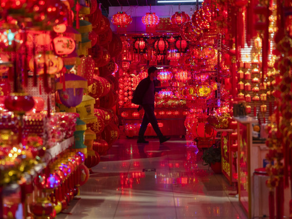 Un uomo cammina tra gli stand delle decorazioni del capodanno cinese a Yiwu