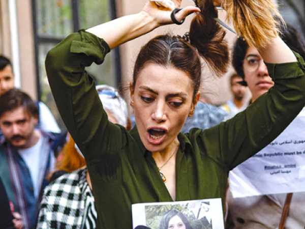 Nasibe Samsaei, una donna iraniana si taglia la coda di cavallo durante una protesta fuori dal consolato iraniano a Istanbul. Uno dei momenti più significativi degli oltre 100 giorni di proteste contro il regime di Teheran a seguito della morte di Masha Ameni il 13 settembre (AFP)
