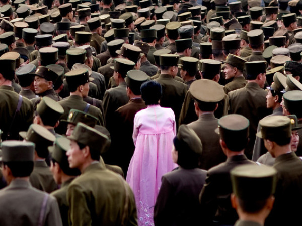Pyongyang (Corea del Nord). Una donna in abito tradizionale in mezzo a centinaia di soldati durante una parata, immortalata da Eric Lafforgue. Il fotoreporter si è recato in Corea del Nord 6 volte nell'arco di 4 anni, tra il 2008 e il 2012. Ma ora gli è stato vietato di tornarci. È stato poi costretto a cancellare molte delle foto realizzate prima di lasciare il Paese, specialmente quelle che mettevano in luce la diffusa malnutrizione e povertà della popolazione, se non per alcuni scatti sottratti alle autorità e salvati su una chiavetta USB (ERIC LAFFORGUE)