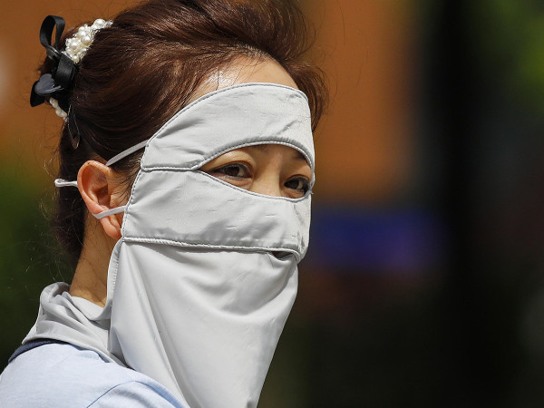 Kuala Lumpur (Malesia). Una donna si copre interamente il viso con una maschera durante una giornata particolarmente calda. Secondo le previsioni del Ministero dell’Energia e delle risorse naturali Nik Ahmad, la Malesia sperimenterà un caldo estremo fino ad agosto, dopo la stagione di transizione dei monsoni