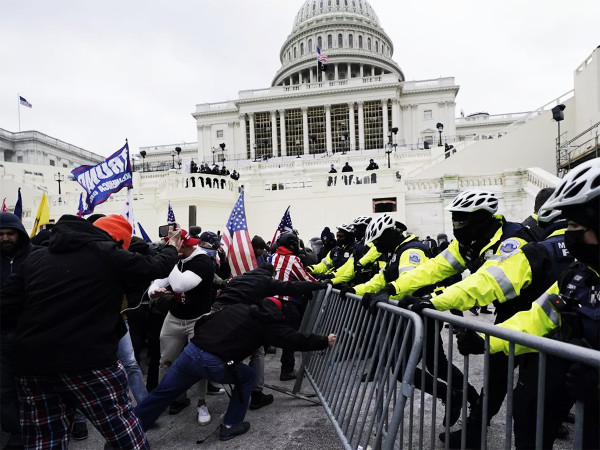 I sostenitori di Trump cercano di sfondare una barriera della polizia al Campidoglio di Washington il 6 gennaio 2021