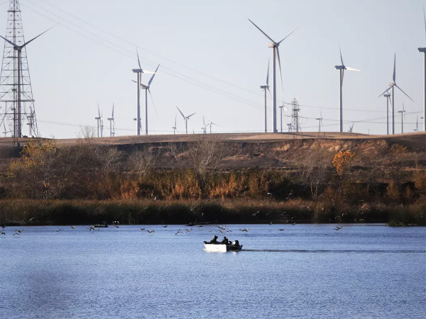 Wind turbines and boaters along the Sacramento River