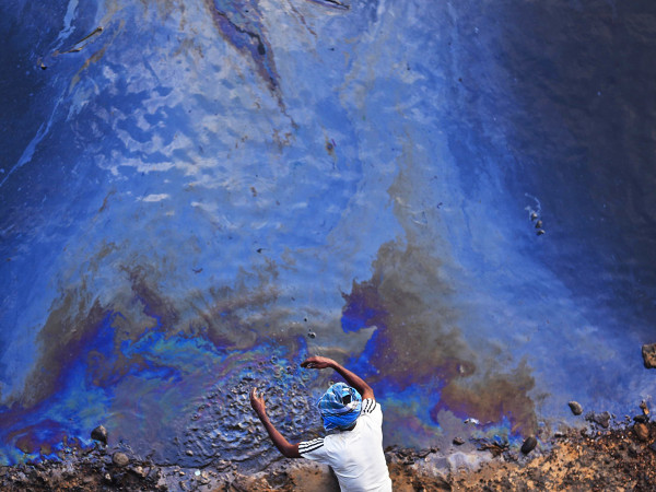 Chennai (India). Un pescatore indiano in riva all'Ennore Creek. Secondo un'indagine della Guardia costiera indiana, la fuoriuscita di petrolio, segnalata nelle acque alluvionali dell'Ennore, dopo il ciclone Michaung, ha ora raggiunto il mare e si estende per 20 km quadrati, dalla foce del fiume Kosasthalaiyar al porto di Kasimedu.