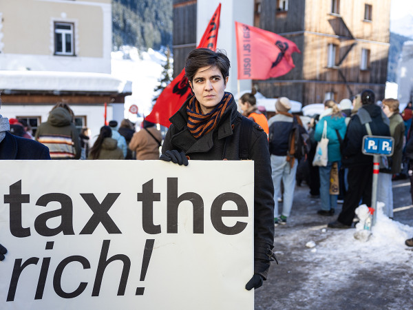 Durante una manifestazione a Davos, l'ereditiera tedesco-austriaca e attivista sociale Marlene Engelhorn tiene un cartello con la scritta "tax the rich!".