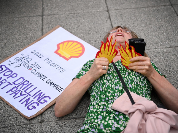 A protester lays on the ground after being carried out of the Shell General Shareholders meeting during a demonstration at the Excel Centre in London, Britain, 23 May 2023.