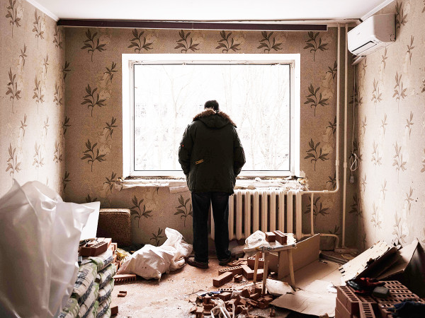 3 gennaio 2024: un uomo guarda fuori dalla finestra del suo appartamento distrutto dopo il massiccio attacco missilistico che ha colpito Kyiv il giorno prima.&nbsp;