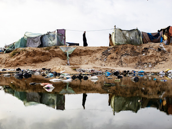 Un palestinese in piedi accanto a una perdita di liquami e rifiuti vicino alle tende per gli sfollati interni in un campo temporaneo nel campo di Rafah, nel sud della Striscia di Gaza, 26 aprile 2024. Dal 7 ottobre 2023, fino a 1,7 milioni di persone, ovvero pi&ugrave; del 75% della popolazione, sono state sfollate in tutta la Striscia di Gaza, alcune pi&ugrave; di una volta, in cerca di sicurezza, secondo l'Agenzia delle Nazioni Unite per il Soccorso e l'Occupazione dei Rifugiati Palestinesi nel Vicino Oriente (Unrwa).&nbsp;