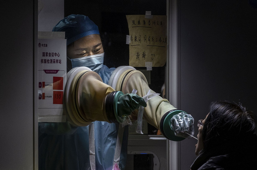 Cina, 13 gennaio 2022. Una donna viene sottoposta a un test COVID-19 da un operatore sanitario in una struttura privata a Pechino.