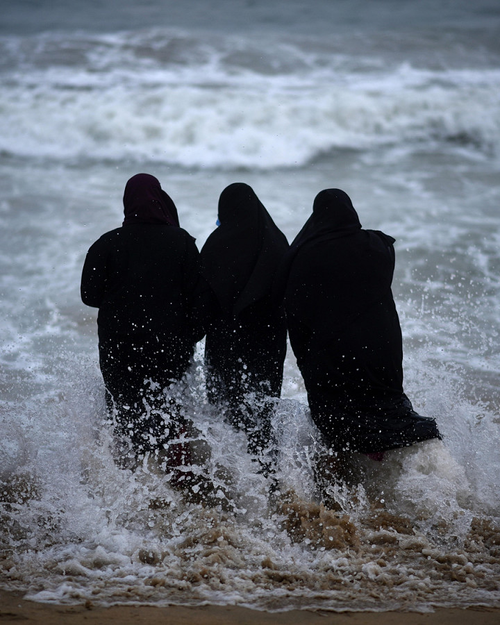 Chennai, India. Tre ragazze di religione musulmana fanno il loro ingresso nel mare a Foreshore Estate beach. Il Governo ha annunciato la riapertura delle scuole per l’1 febbraio 2022.