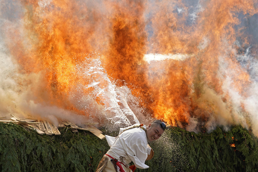 Hachioji (Giappone). In una delle citt&agrave; del distretto di Tokyo, un monaco getta l’acqua su un fuoco sacro durante il festival di Takao-san Yakuo-in. (EPA/FRANCK ROBICHON)
