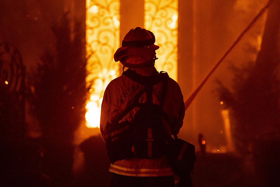 Laguna Niguel (California). Un vigile del fuoco &egrave; impegnato a spegnere un incendio in una casa avvolta dalle fiamme. Ammonterebbe a 20 il numero di ville lussuose rase al suolo dal fuoco divampato nella contea di Orange. (EPA/ETIENNE LAURENT)