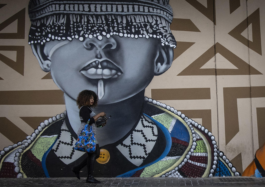 Johannesburg (Sudafrica). Una donna passa davanti a un murales nel distretto di Maboneng durante l&rsquo;Africa Day, giornata in cui si celebra l&rsquo;anniversario della fondazione dell’Organizzazione dell’Unit&agrave; Africana, avvenuta il 25 maggio 1963. 