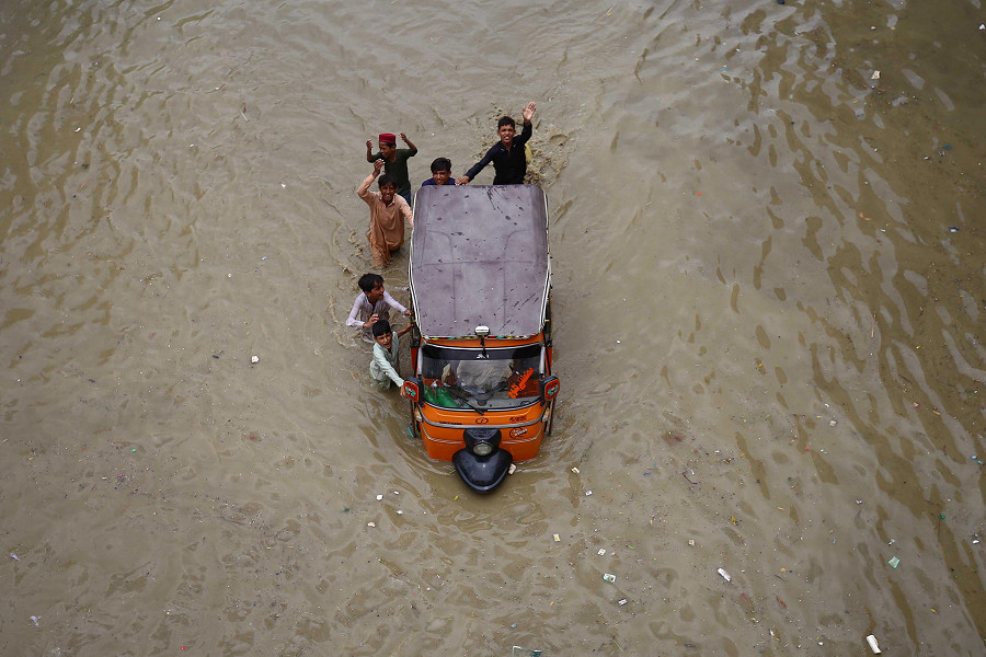 Karachi (Pakistan). Un gruppo di bambini si fa strada in un’area allagata dopo le forti piogge monsoniche che finora hanno provocato 77 vittime nel Paese. La regione del Balochistan &egrave; stata la pi&ugrave; colpita, con il 274% di precipitazioni in pi&ugrave; rispetto alla media