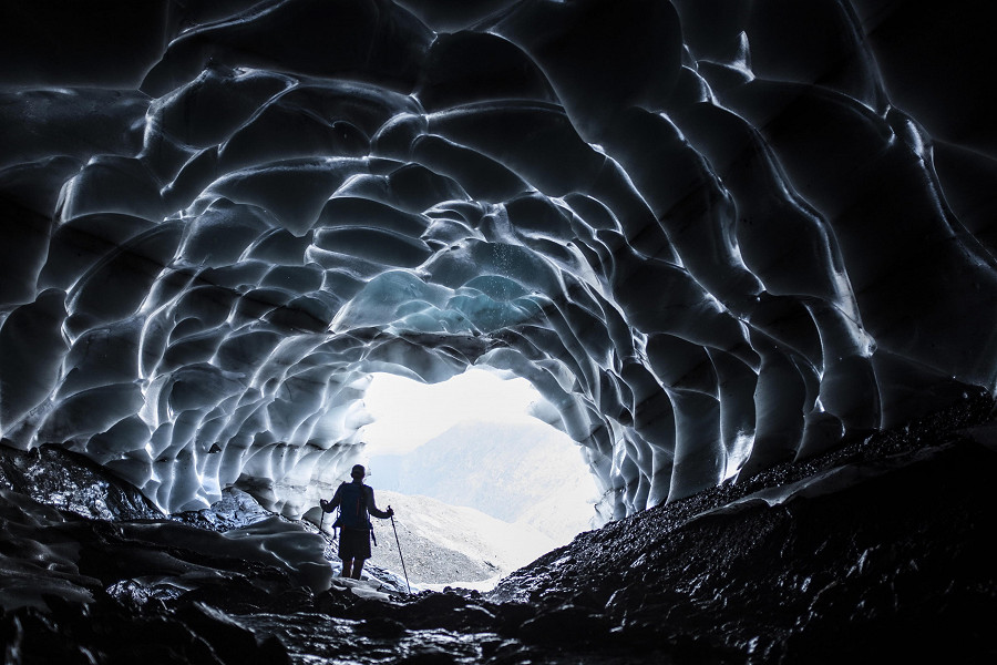 V&auml;ttis (Svizzera). Un uomo osserva il paesaggio da una grotta del ghiacciaio di Sardon, nel nord del Paese, rivelata dallo scioglimento dei ghiacci a causa delle alte temperature.