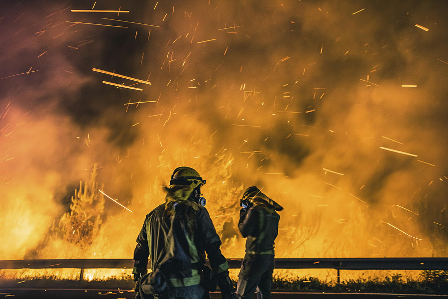 Boiro (Spagna). I vigili del fuoco combattono le fiamme di un incendio boschivo nella parrocchia di Cures, in Galizia, nella Spagna nord-occidentale. L’incendio boschivo, scoppiato il 4 agosto, ha distrutto finora 2200 ettari ed &egrave; ancora fuori controllo. 