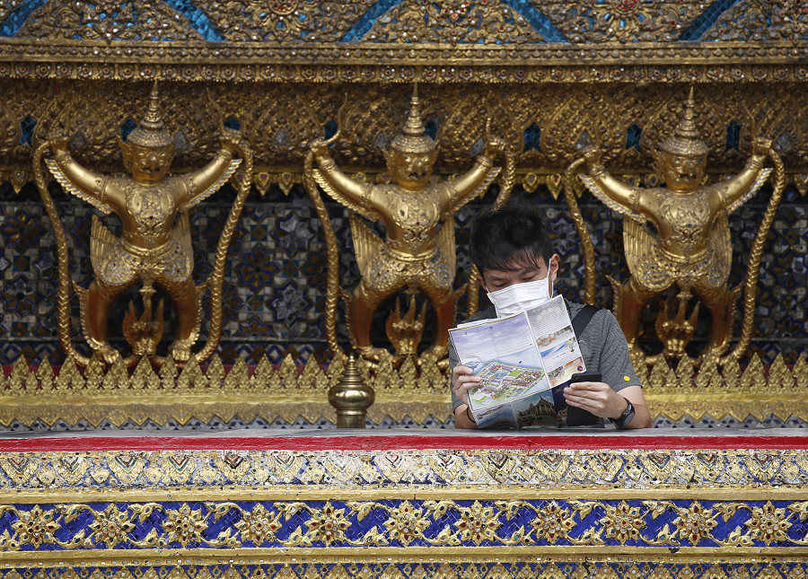 Bangkok (Thailandia). Un turista guarda una mappa durante la sua visita al Tempio del Buddha di Smeraldo all’interno del Grand Palace. Il numero di visitatori stranieri arrivati nel mese di luglio 2022 ha registrato un forte aumento rispetto all’anno precedente, con 1,12 milioni di visitatori: sono i segni positivi della ripresa economica del Paese dopo l’alleggerimento delle misure anti-pandemia.