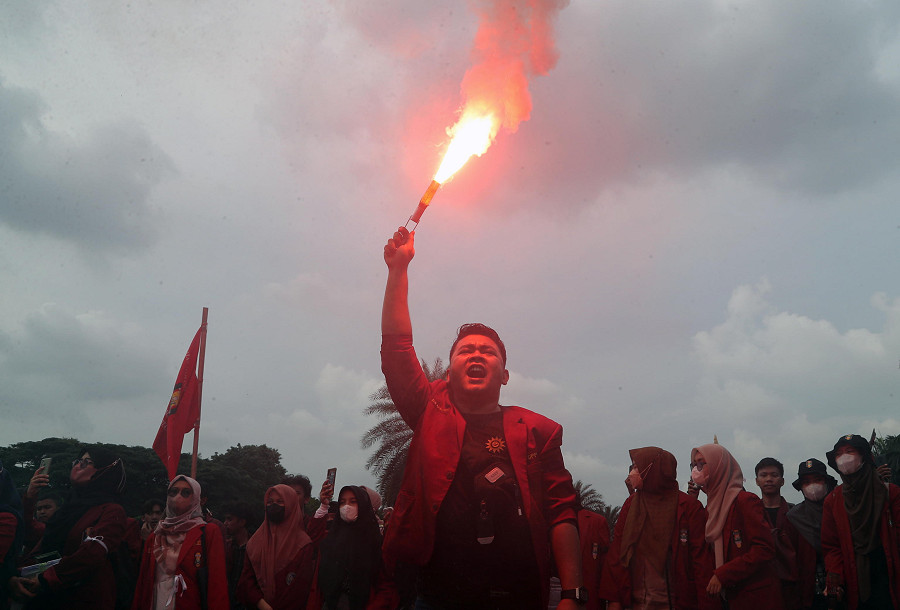 Giacarta (Indonesia). Uno studente indonesiano alza la sua torcia durante una manifestazione vicino al Palazzo presidenziale contro l’aumento dei prezzi del carburante, gonfiati del 30% a causa dell’inflazione.