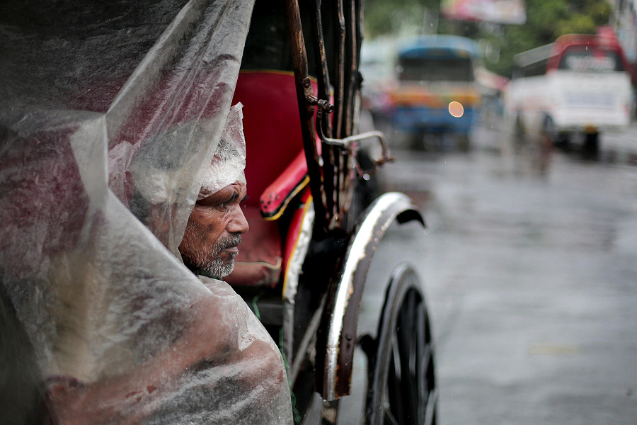 Calcutta (India). Un risci&ograve; e il suo autista aspettano passeggeri durante una piovosa giornata nella capitale dello stato indiano del Bengala Occidentale. 