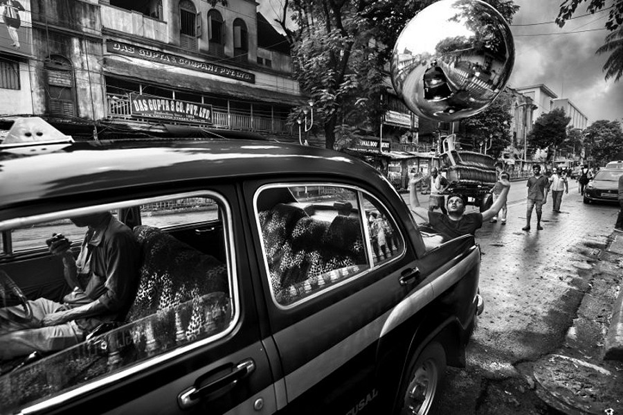 Max Vadukul, Taxi driver lunch vs zero emission man, dalla serie “The Witness”, college street, Calcutta (India), 2019