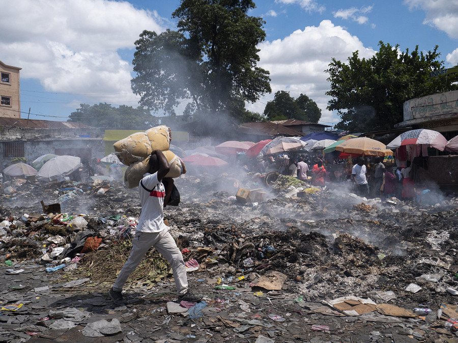 Port-au-Prince (Haiti). Un uomo cammina per una strada disseminata di spazzatura. Il governo haitiano ha chiesto ai suoi partner internazionali il dispiegamento immediato di una forza armata specializzata volta ad affrontare il gravi problemi nel Paese, peggiorati in seguito all’assassinio del presidente Jovenel Moise nel luglio 2021.