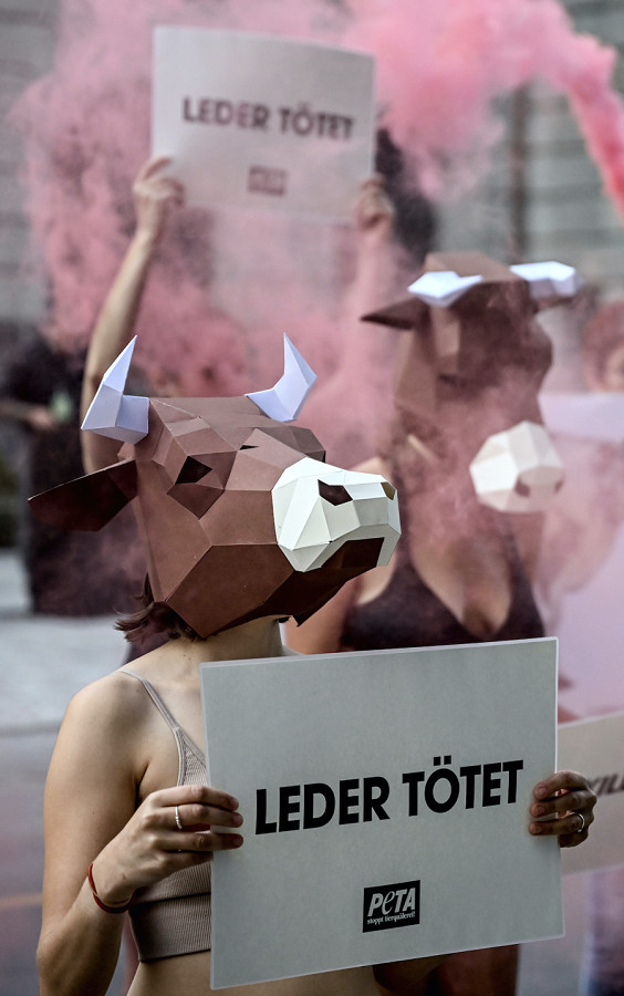 Berlino (Germania). Una manifestante dell’organizzazione animalista PETA tiene in aria dei cartelli con la scritta “La pelle uccide” durante la Mercedes-Benz Creators Night della Mercedes-Benz Fashion Week al Telegraphenamt in occasione della Settimana della moda di Berlino. 