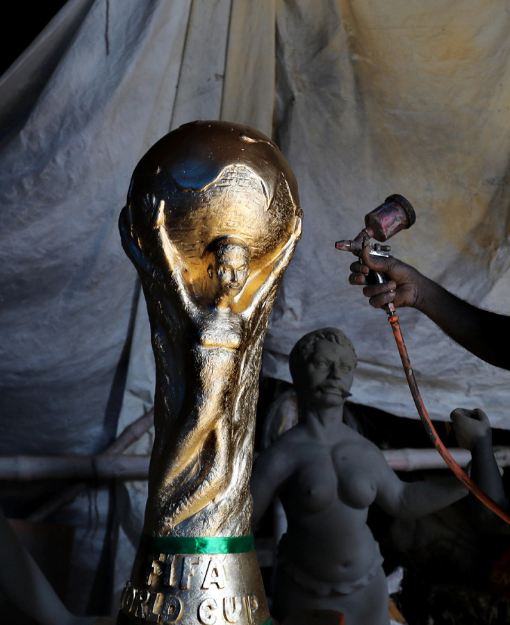 Kolkata (India). Un artista lavora su un modello in argilla della Coppa del Mondo FIFA in un laboratorio locale. L’oggetto &egrave; parte delle decorazioni realizzate per l’evento calcistico che si svolge in Qatar dal 20 novembre al 18 dicembre. 