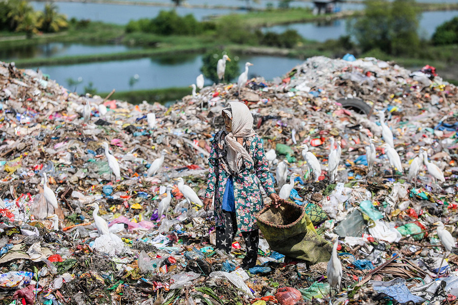 Medan (Indonesia). Una spazzina raccoglie materiali plastici in una discarica nella Sumatra Settentrionale. Secondo un documento del ministero dell’Ambiente indonesiano, il paese ha prodotto pi&ugrave; di 30,8 milioni di tonnellate di rifiuti nel 2021, il 17,6% dei quali rappresentato dalla plastica.