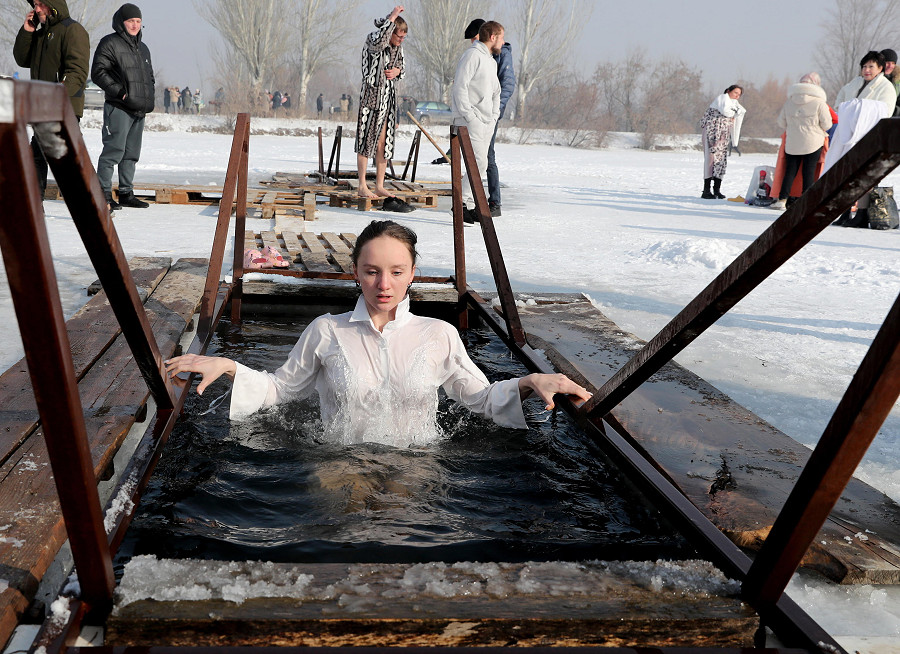 Leninskoye (Kirghizistan). Una donna si immerge in un lago ghiacciato in occasione dell’Epifania ortodossa: le persone credono che fare il bagno nelle acque benedette durante questa celebrazione rafforzi lo spirito e il corpo.