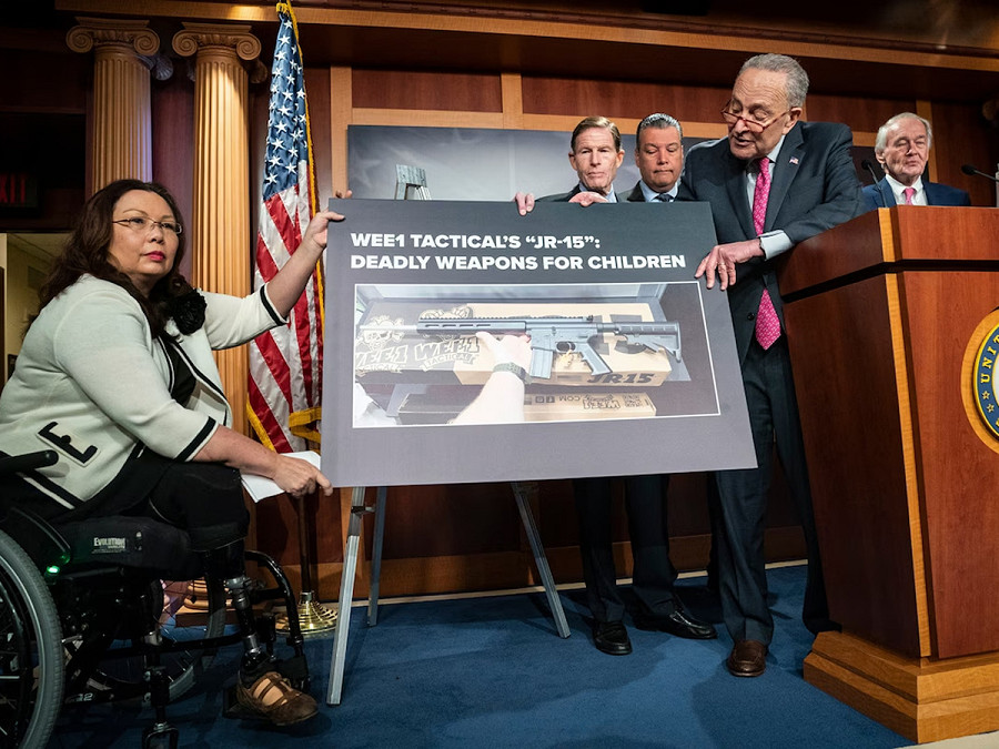 Washington D.C. (Stati Uniti). Il senatore Tammy Duckworth e il leader della maggioranza al Senato Charles E. Schumer sostengono un cartello nel corso di una conferenza stampa indetta per sollecitare la Federal Trade Commission a indagare sulla commercializzazione del fucile JR-15 destinato ai bambini.