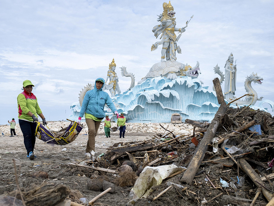 Bali (Indonesia). Alcune operatrici ripuliscono la spiaggia di Kuta dai detriti e rifiuti di plastica che durante la stagione delle piogge finiscono in mare a causa della mancanza di un sistema centralizzato di gestione dei rifiuti sull’isola. 