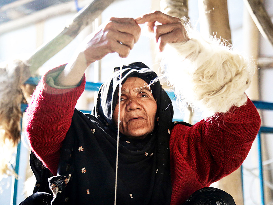 Kabul (Afghanistan). Una donna afghana mentre lavora in una fabbrica di tappeti. Le donne e le ragazze si sono rivolte all’industria della tessitura e della produzione di tappeti a causa delle restrizioni imposte dal Governo talebano, che hanno ostacolato o impedito il loro accesso al lavoro e all’istruzione.
