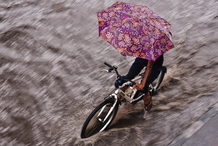 Chennai (India). Un uomo in bicicletta si ripara dalla pioggia con un ombrello. Per i prossimi giorni, l’Indian Meteorological Department (Imd) ha previsto precipitazioni da deboli a moderate con temporali, fulmini, e raffiche di vento nello stato del Tamil Nadu e in India meridionale.