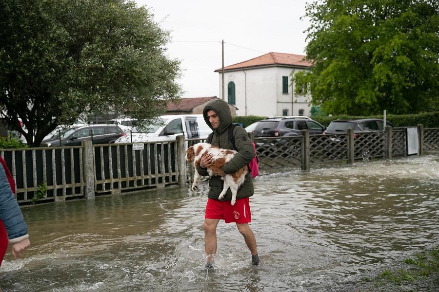 Lugo (Italia). Un ragazzo porta in salvo il suo cane dopo l’alluvione.