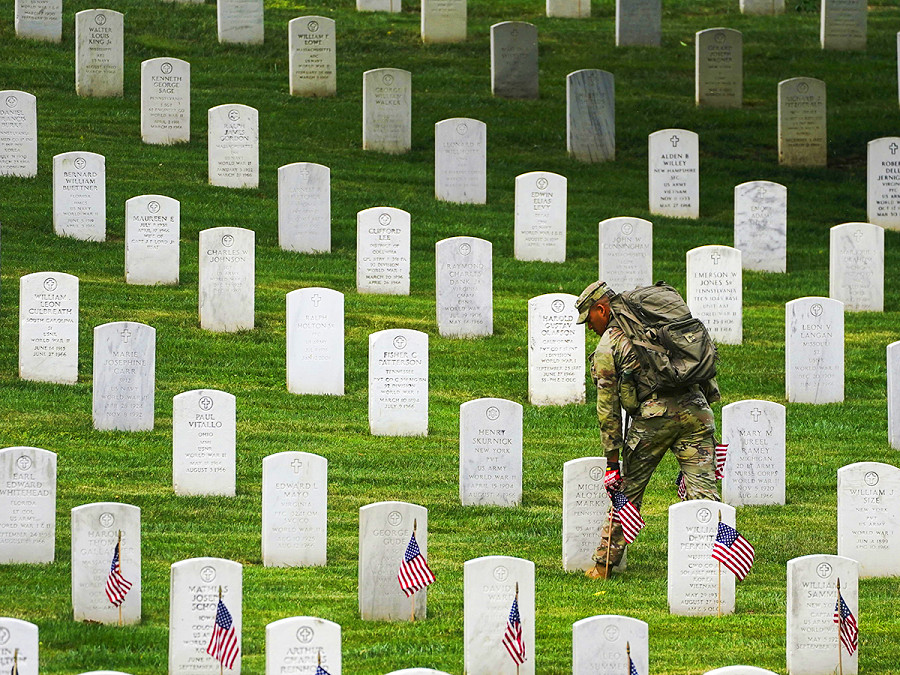Arlington (Stati Uniti). Un soldato posiziona le bandiere americane lungo migliaia di lapidi prima della cerimonia “Flags-In”, al cimitero nazionale della Virginia. Ogni anno, prima del week-end del Memorial Day, i membri del 3&deg; reggimento di fanteria onorano i 400.000 caduti statunitensi sepolti qui. 