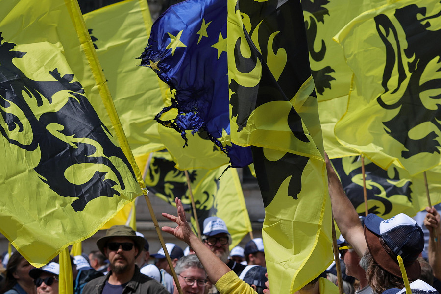 Bruxelles (Belgio). Dei sostenitori del partito di destra fiammingo Vlaams Belang sventolano una bandiera dell’Ue parzialmente bruciata durante una manifestazione prima vietata dal sindaco di Bruxelles e poi autorizzata dal Consiglio di Stato belga. 