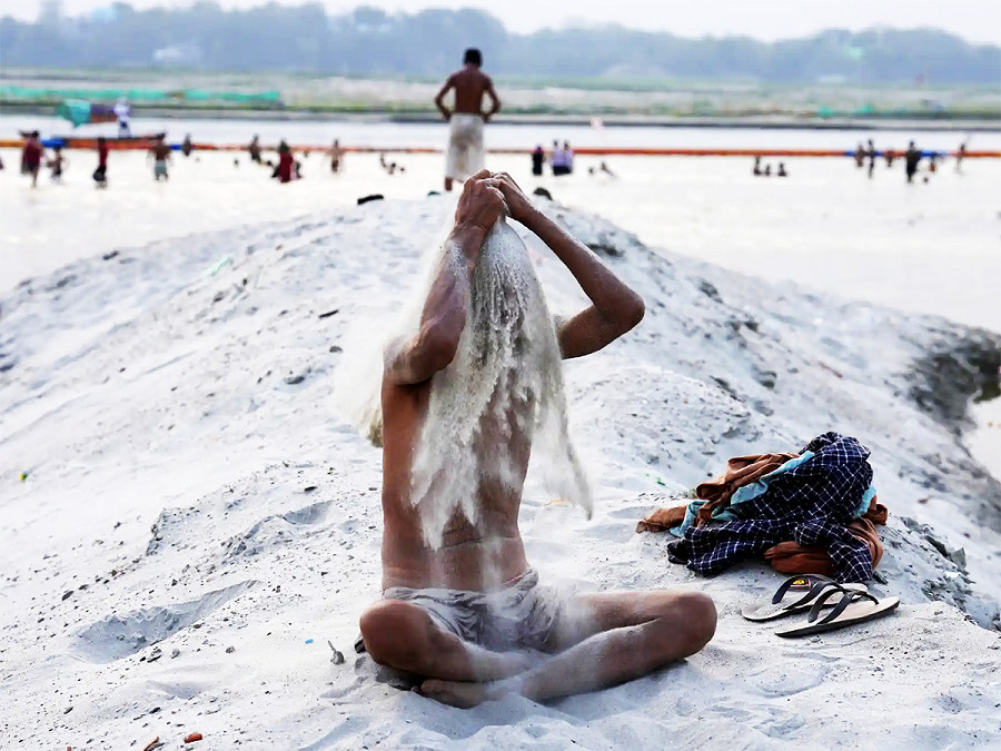 Prayagraj (India). Un devoto ind&ugrave; fa un bagno di sabbia a Sangam, il punto in cui confluiscono i fiumi Gange e Yamuna, nello stato indiano settentrionale dell’Uttar Pradesh 
