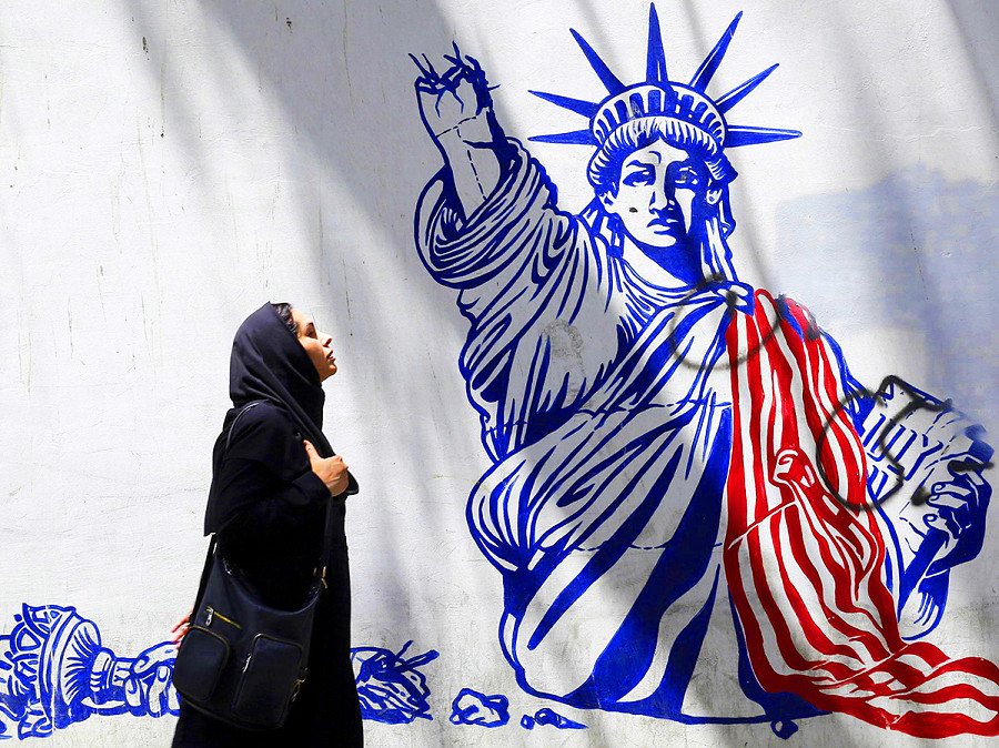 Teheran (Iran). Una donna iraniana cammina accanto a un murale anti-Usa. Domenica 11 giugno, durante un incontro con gli scienziati nucleari iraniani, la Guida Suprema Ali Khamenei ha dichiarato che l’Occidente non pu&ograve; fermare i progressi nucleari dell’Iran, esortando a continuare a collaborare con l’Agenzia Internazionale per l’Energia Atomica. 
