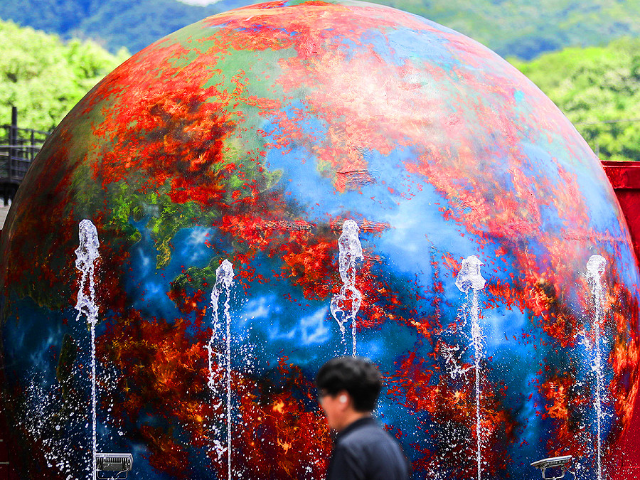 Seoul, Corea del Sud. Un uomo passa davanti a un’installazione che rappresenta il Pianeta in fiamme in un parco a Daegu, 237 chilometri a sud-est di Seoul. Nella regione &egrave; stato emesso un allarme meteo per le ondate di caldo. 