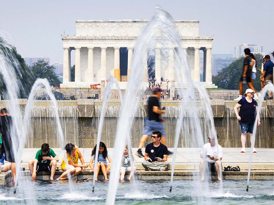 Washington DC, USA. I visitatori del Memoriale della Seconda Guerra Mondiale si rinfrescano vicino la fontana. Gli Stati Uniti stanno vivendo un&rsquo;ondata di caldo che non si registrava dagli anni &rsquo;90