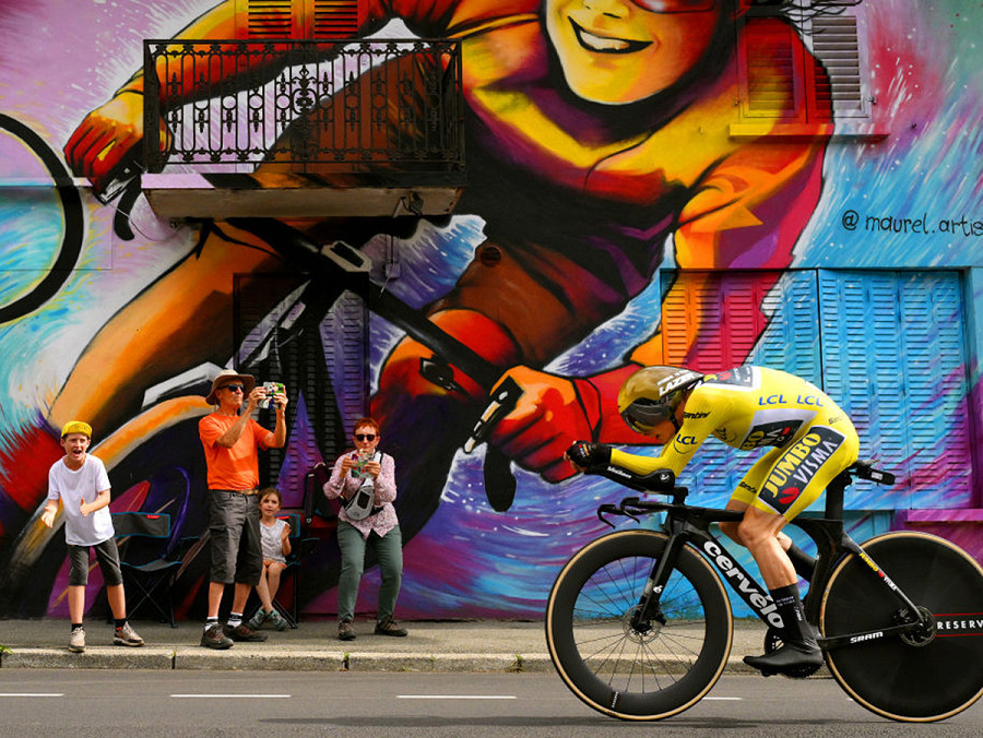 Combloux, Francia. Un ciclista corre davanti a un murale durante la 16esima tappa del Tour de France