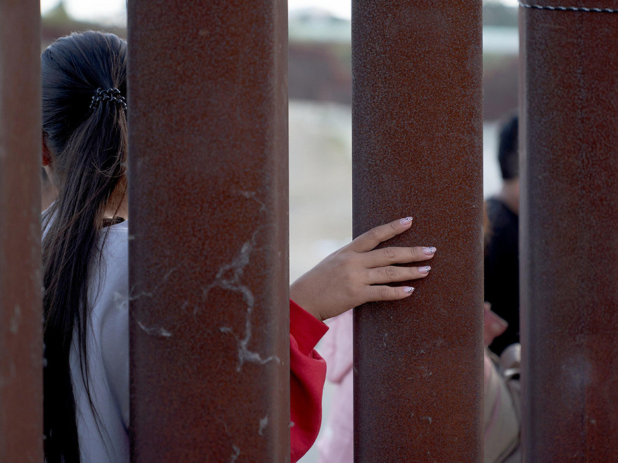 San Diego (Stati Uniti). Una donna infila la mano attraverso la recinzione di confine tra Usa e Messico. Secondo i dati dell&rsquo;US Customs and Border Protection gli attraversamenti illegali sono in aumento e i centri di detenzione sono al completo in tutta l&rsquo;area. 