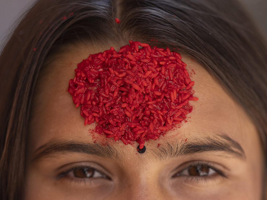 Lalitpur (Nepal). Una donna che indossa tika sulla fronte posa durante il decimo giorno del Dashain, il festival pi&ugrave; lungo e importante del Paese, tenuto in onore della dea Durga per commemorare la vittoria degli dei sui demoni. 