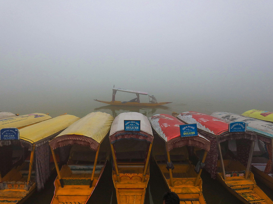 Srinagar (Kashmir indiano). Una barca solca le acque del lago Dal in una mattina nebbiosa a Srinagar, la capitale estiva del Kashmir indiano. Nella regione, si &egrave; registrato un notevole e improvviso calo delle temperature. 